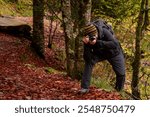 A photographer taking pictures in an autumn forest