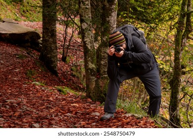 A photographer taking pictures in an autumn forest - Powered by Shutterstock