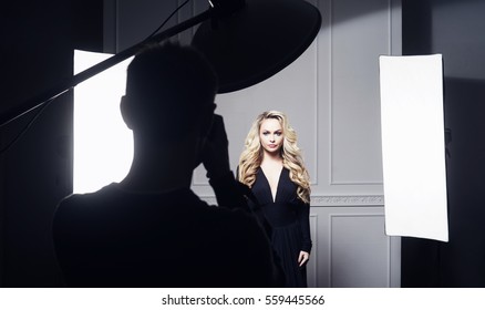 Photographer Taking Pictures Of A Beautiful Model In Studio. Fashion, Beauty, Glamour Concept. 