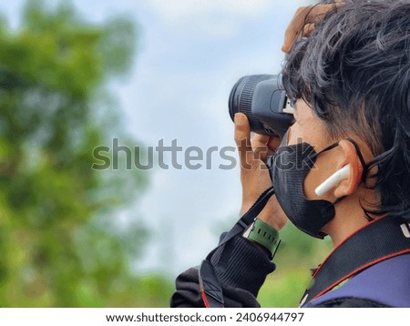 Photographer is taking pictures of sky objects in nature. nature portrait using dslr camera. Asian man try Dslr camera.
