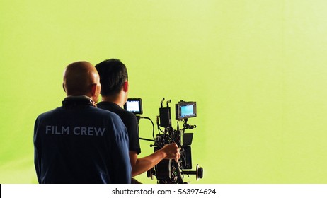 Photographer Team And Film Crew And Movie Camera And Green Screen Studio.