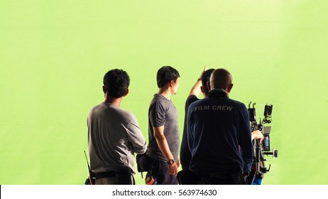 Photographer Team And Film Crew And Movie Camera And Green Screen Studio.