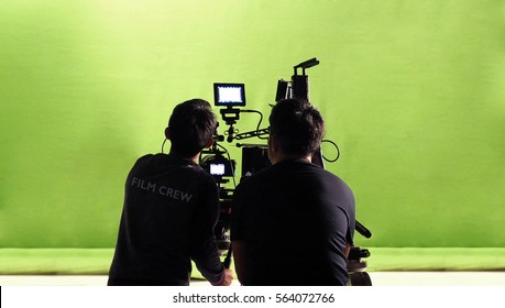 Photographer Team And Film Crew And Movie Camera And Green Screen Studio.