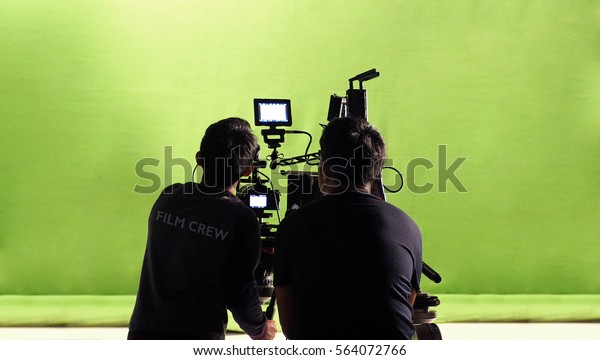 Photographer team and film crew and movie camera\
and green screen\
studio.