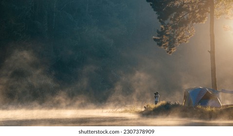 Photographer travel and camping alone at natural park in Thailand. photographer takes pictures morning fog - Powered by Shutterstock