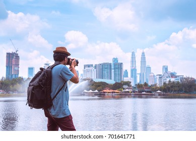 Photographer Or Traveller Using A Professional DSLR Camera Take Photo Beautiful Landscape Of Kuala Lumpur Skyscraper At Titiwangsa Park Kualalumpur City, Malaysia.