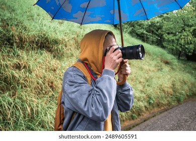 Photographer with Umbrella Capturing Outdoor Shots - Powered by Shutterstock