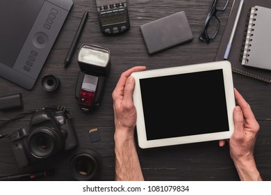 Photographer using blank digital tablet on workplace with photo equipment, scrolling photos, technology and communication concept, top view, copy space - Shutterstock ID 1081079834