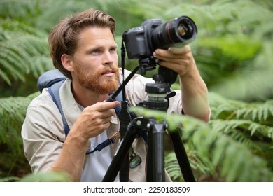 photographer using a tripod to take photos - Powered by Shutterstock