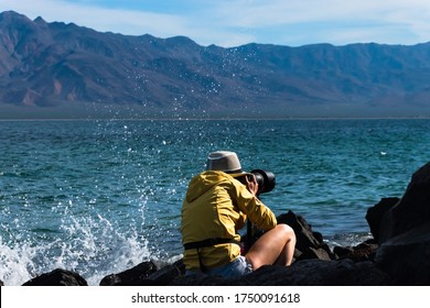 Photographer Woman Captured While Shooting Wildlife On A Beautiful Seascape With Mountain Range And Turquoise Water In Baja California