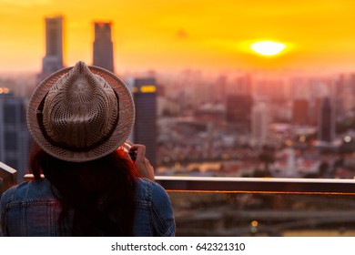 Photographer  woman shooting Marina Bay in Singapore at sunset. - Powered by Shutterstock