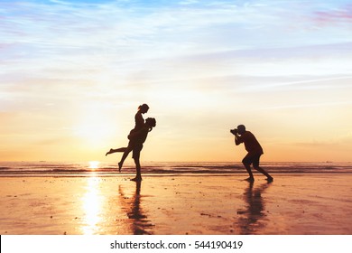 photographer working with couple on the beach, professional wedding photography