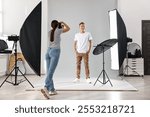 Photographer working with model in professional photo studio