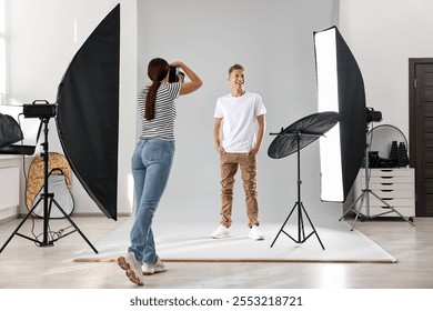 Photographer working with model in professional photo studio - Powered by Shutterstock