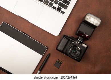 Photographer workplace with digital camera, flash, computer and graphic tablet on leather texture.tif - Powered by Shutterstock