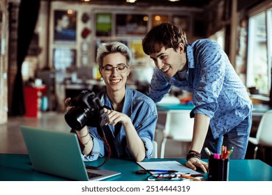 Photographers reviewing images on a camera in a creative studio - Powered by Shutterstock