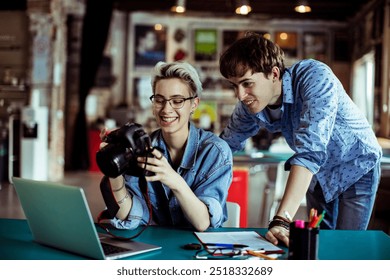 Photographers reviewing images on a camera in a creative studio - Powered by Shutterstock