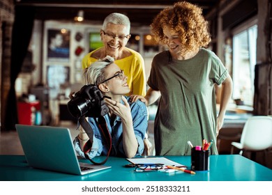 Photographers reviewing images on a camera in a creative studio - Powered by Shutterstock