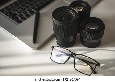 Photographer's workplace with a different prime lenses on white table