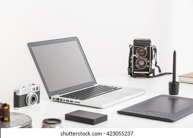 Photographers workspace. Workspace with notebook, camera and tablet. White table of a creative designer or photographer with laptop, tablet, camera and copy space. Mock up