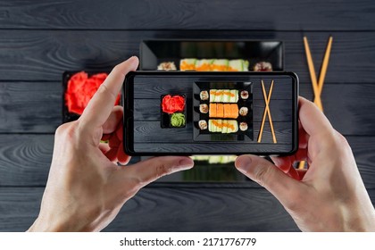 Photographing food on a mobile phone. Professional photography of food in the studio on a mobile phone. Photographing on the phone for a blog in social networks. Shooting sushi on a mobile phone.