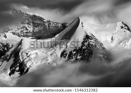 Photographing a snowy mountain and clouds going in the city of Interlaken
