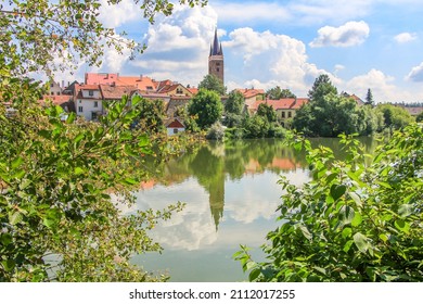 Photographing the town Telc from lake Ulicky with blue sky, green trees and baroque architecture. The building surrounding by the trees and river.
Located at Unesco Czech republic, Europe.