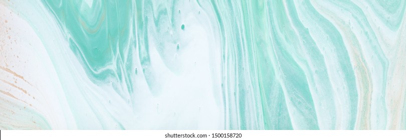 photography of abstract marbleized effect background. turquoise, gold, blue and white creative colors. Beautiful paint. banner