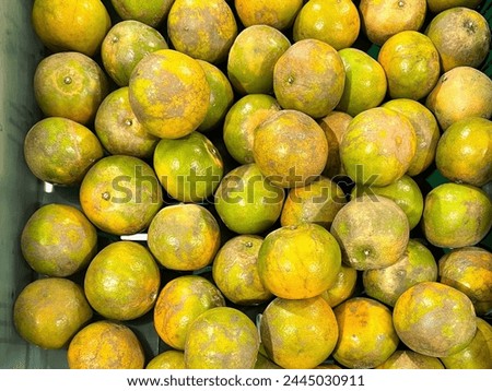 a photography of a bin full of oranges with a lot of rotten ones.