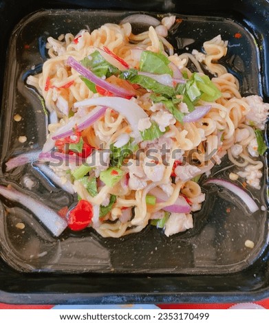 a photography of a black plate with noodles and vegetables in it, tray of noodles with meat and vegetables in it on a table.