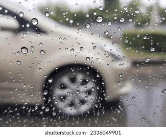 a photography of a car is seen through a rain covered window, view of a car through a rain covered window. - Powered by Shutterstock