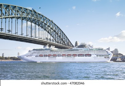 A Photography Of A Cruise Ship Passing Sydney Harbour Bridge