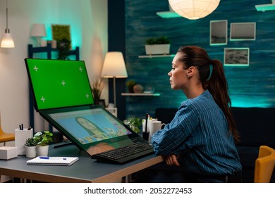 Photography designer working on retouching photo with green screen on display. Professional woman using mockup template and isolated chroma key on graphic software in editing studio