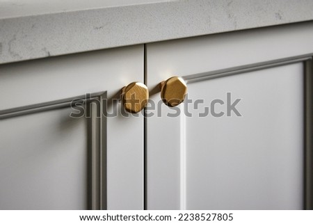 Photography detail of shaker style kitchen cupboard joinery doors and brushed gold handles.