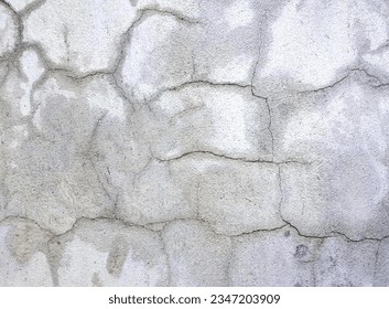 a photography of a fire hydrant sitting on top of a cement wall, stone wall with cracks and cracks in it.