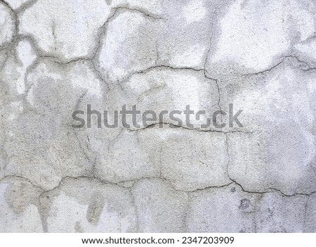 a photography of a fire hydrant sitting on top of a cement wall, stone wall with cracks and cracks in it.