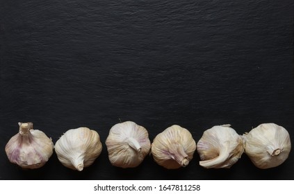Photography of garlic heads on slate background for restaurant menu or market sign