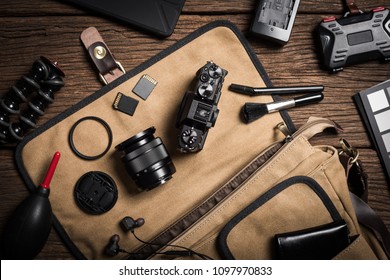 photography gear on wooden table, digital camera lens and other accessories.