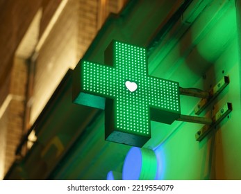 Photography of a green cross, the symbol used for medical intitutions. Symbol is located on the exterior of a building. Moscow city in night  - Powered by Shutterstock