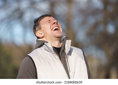 Photography of happy laughing handsome man. Portrait at sunny spring day on the city street. His mood is good, even excellent. Close up image like a promo action