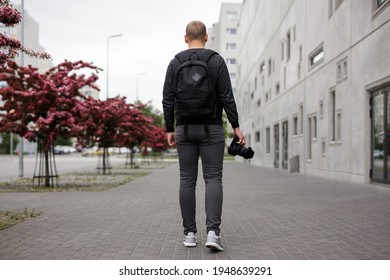 Photography, Hobby, Art And Creativity Concept - Back View Of Male Photographer With Modern Dslr Camera Walking In Modern City