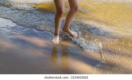 Photography Of Human Feet. One Person Walking On The Sandy Beach. Vacations Concept. Close Up Photography