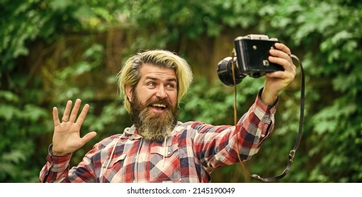 photography in modern life. travel tips. professional photographer use vintage camera. selfie time. bearded man hipster take photo. photo shooting outdoor. brutal man traveler with retro camera