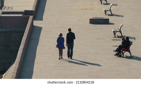 Photography Of Moscva River Embankment In Sunny Spring Day. The Beauty Of The Capital. One Couple Of Young Man And Woman Sitting On The Bench, Other Walking. View From Above, Top View