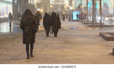 Photography Of People Put On Black Warm Winter Clothes At City Street At Winter Night. Lights Of The Moscow City As Background. Cold. Backs, Rear View