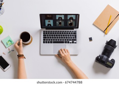 photography, people and technology concept - hands of photographer with camera reviewing model photoshoot on laptop computer screen at table - Powered by Shutterstock