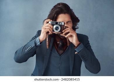 Photography, portrait and man in studio with vintage camera, press or shutter on dark background. Professional photographer, journalist or tech for capture in freelance work, reel development or film - Powered by Shutterstock