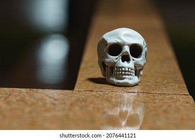 Photography of a skull toy on a marble parapet on the street Moscow in night. Front view. Long exposure image. Halloween theme - Shutterstock ID 2076441121