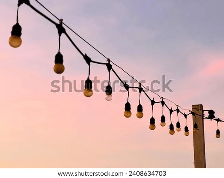 a photography of a string of light bulbs hanging from a pole.
