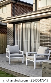 Photography Of A Suburban Family Home, Outdoor Furniture Setting In An Al Fresco Patio Area With The Main House In The Background.